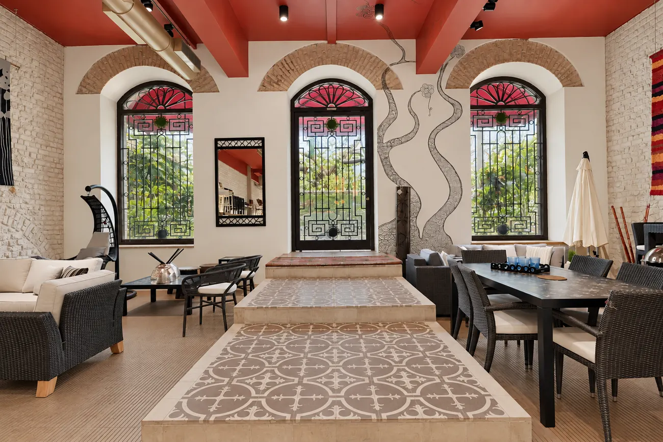 Entrance area at Abaca with three arched windows, patterned tile flooring and a hand-drawn tree on the wall.