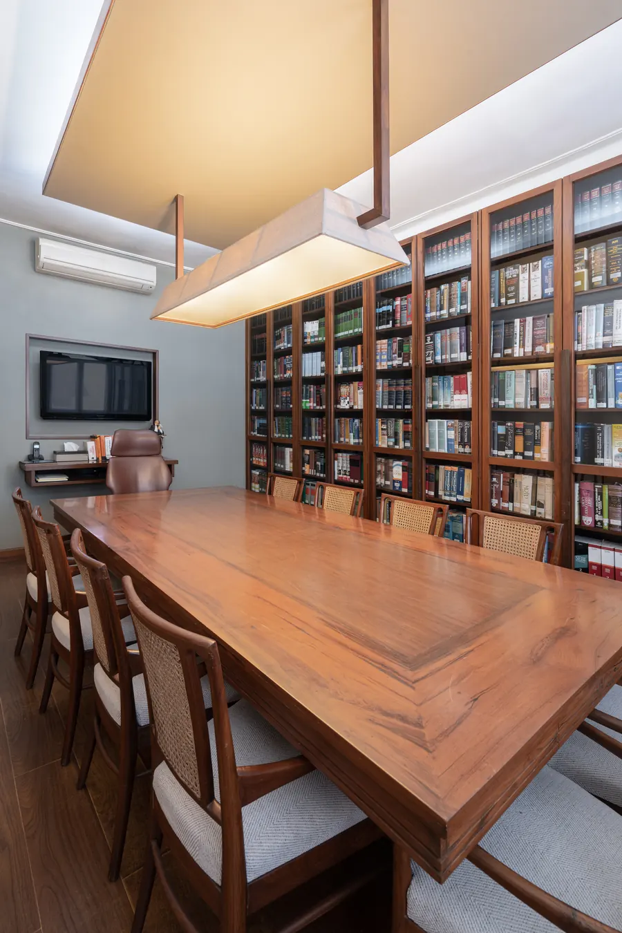 Library conference room at Lawyers Chambers with a long wood table, cane-backed chairs and glazed bookcases of law books.