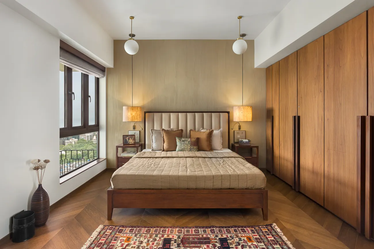 Walnut chevron-panelled wall at Zara with a framed painting, beneath a pendant light, beside a beige sofa on a Kilim rug.