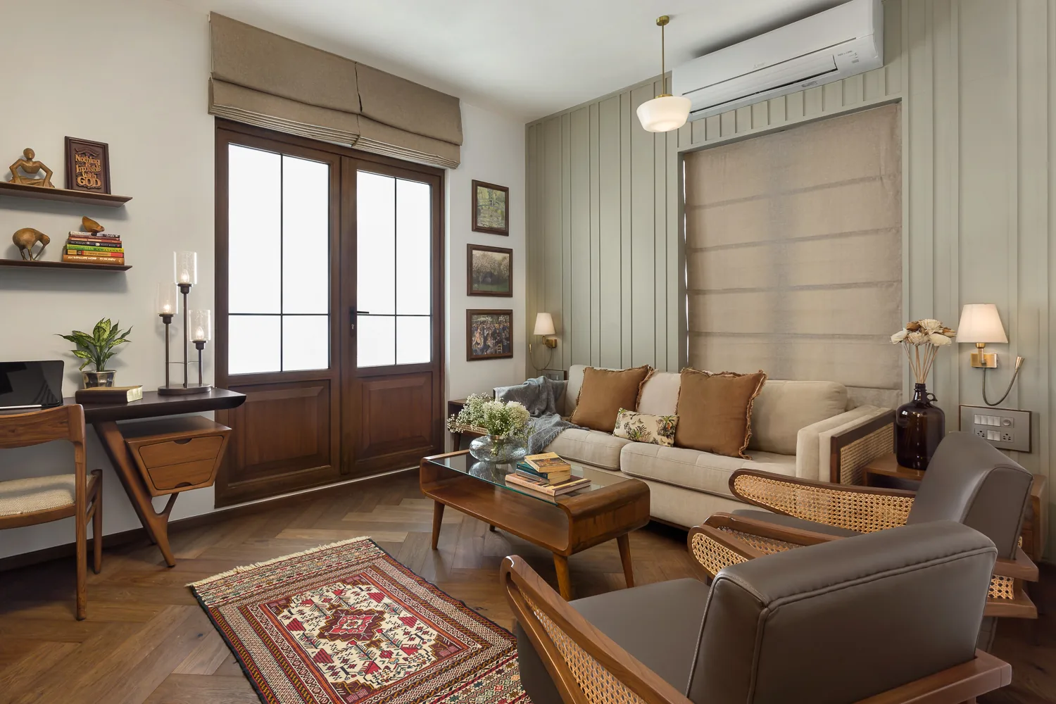 Study at Zara with a timber writing desk, cane-backed lounge chairs, a beige sofa against a panelled wall and a kilim on a herringbone timber floor.